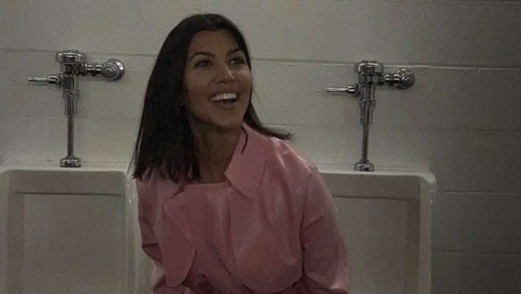 Kourtney Kardashian Models A Pink Trench Coat In The Men's Bathroom